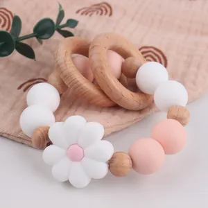 Detail of baby teething ring with pink silicone beads, daisy flower and wooden rings
