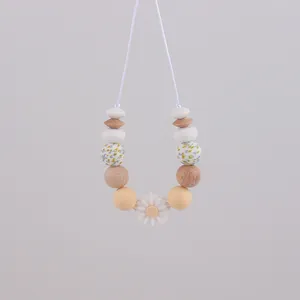 Detail of baby teething necklace with silicone floral beads and wooden accents