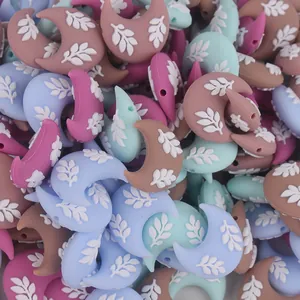 Vista macro di perline in silicone a forma di luna con motivi a foglia multicolore