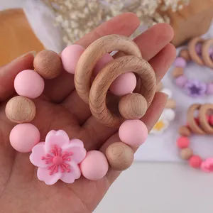 Detail of pink silicone flower baby teether rattle with natural beech wood rings
