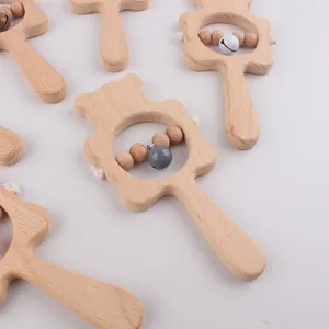Detailed close-up of smooth beech wood baby rattle with bear shape and small bell