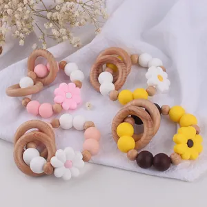 Close-up of baby teething rings with daisy silicone charms and natural beech wood beads