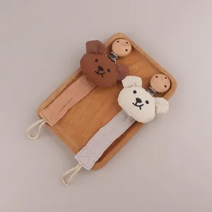 Detail of soft cotton bear pacifier clip with natural wooden clasp for babies