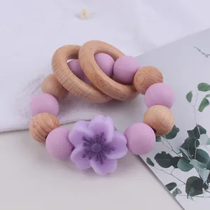 Close-up of a beech wood and purple silicone floral teething ring for newborn babies