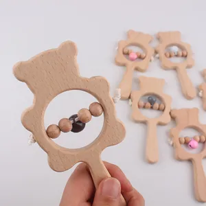 Close-up of a bear-shaped beech wood baby rattle with colorful beads and natural texture