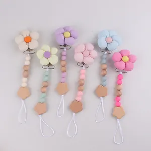 Detailansicht von Baby-Schnullerketten mit Stoffblumen sowie Silikon- und Holzperlen
