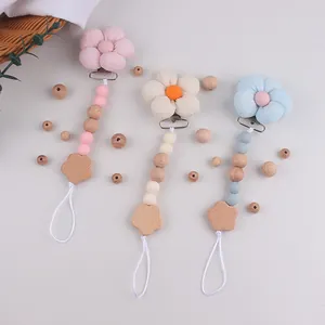 Detailansicht der Schnullerketten mit Stoffblumen und Holzperlen in Pastellfarben