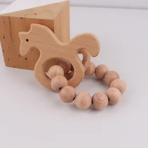 Macro detail of natural beech wood horse teether and smooth wooden beads for infants