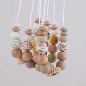 Detail of silicone and wood teething beads with daisy floral prints and sunflower charms