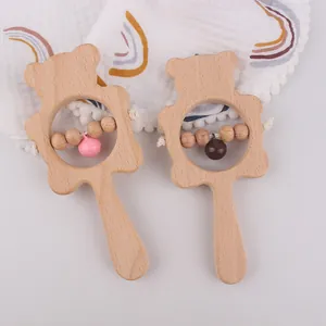Detail of two wooden bear rattles for infants showing round beech beads and metal bells