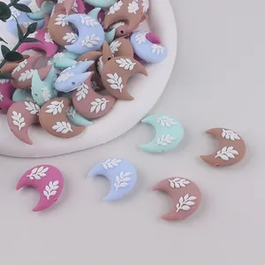Vista macro di perline in silicone a mezzaluna con foglie a rilievo per gioielli fai da te