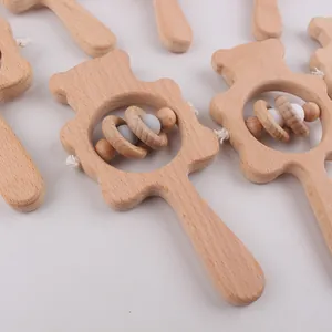 Gros plan d'un hochet bébé ours en hêtre avec anneaux lisses et perles en silicone
