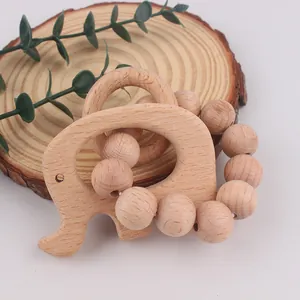 Detail of beech wood elephant teether and natural beaded rattle for newborn babies