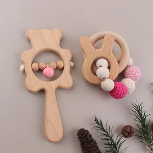 Detailed shot of wooden baby rattles featuring bear and rabbit shapes with crochet beads