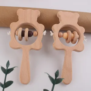 Détail de hochets en hêtre pour bébé avec silhouettes d'ours et perles colorées lisses