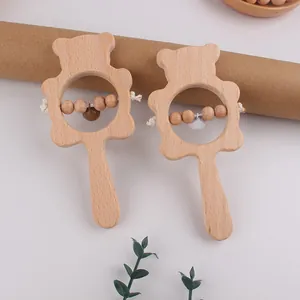 Detail of beech wood bear rattles with small bells and beads for baby sensory play