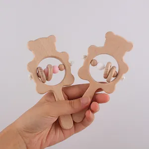 Gros plan d'un hochet en bois de hêtre pour bébé avec des perles en silicone colorées