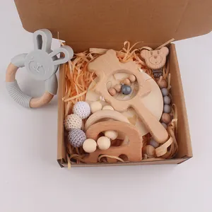 Gros plan du coffret cadeau bébé en hêtre et silicone avec hochets et attache