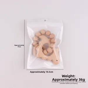 Detailed view of a dinosaur-shaped wooden baby teether with smooth beads and size info