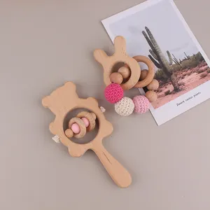 Detail showing handcrafted beech wood bear rattle and rabbit ear teething ring set