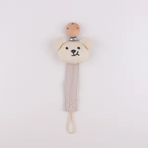 Detailed view of baby pacifier clip with plush cartoon bear and natural wood clip