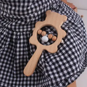 Close-up of wooden bear baby rattle with natural texture and small white bell