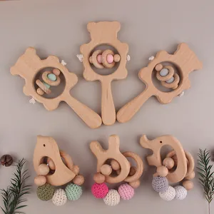 Detail of wooden baby rattle set with bear motifs, silicone beads and knitted textures