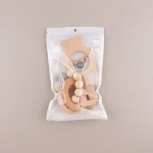 Detail of baby beech wood teether set with animal ring and bell in transparent packaging