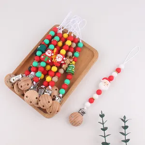 Detail of Christmas themed baby pacifier clips with festive silicone beads and wooden clip