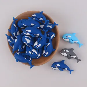 Macro view of 3D orca silicone beads in blue and grey with holes for DIY jewelry
