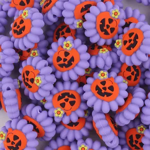 Dettaglio macro di perline in silicone viola a forma di fiore con zucca per DIY Halloween