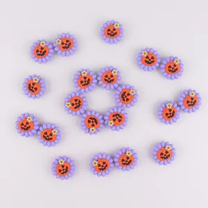 Dettaglio di ciondoli a fiore viola con centri a faccia di zucca per scarpe Halloween