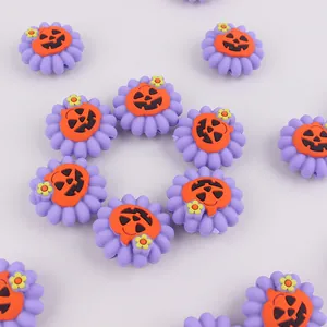 Dettaglio di perline in silicone di Halloween con petali viola e volti di zucca arancio