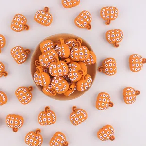 Dettaglio di perle in silicone a forma di zucca con motivi floreali in una ciotola