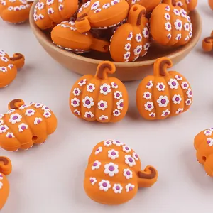 Dettaglio di perline in silicone a zucca arancione con fiori per decorazioni fai-da-te