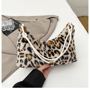 Detail of leopard print faux fur shoulder bag with white leather straps and gold rings