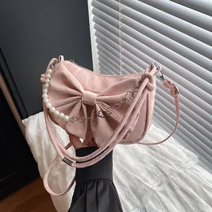 Pink bow shoulder bag with pearl accents and floral metal chain in a soft velvet texture