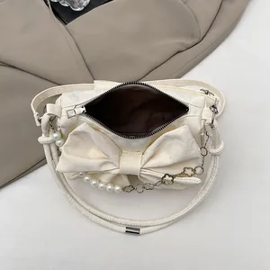 Chic cream-colored bow shoulder bag with pearl metal chain strap and zip closure