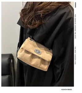 Détail du sac à bandoulière en daim beige avec boucle en strass et design plissé élégant