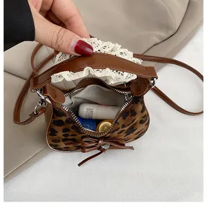 Dettaglio interno della mini borsa leopardata con balsamo labbra e fodera a spina di pesce
