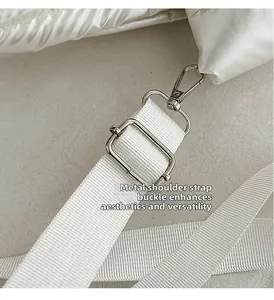 Detail of adjustable silver metal buckle and durable white woven strap on quilted shoulder bag