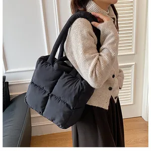 Close-up of black quilted shoulder bag with soft padded handles and large grid pattern