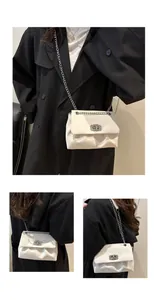 Détails du sac blanc à chaîne avec boucle argentée et texture plissée douce