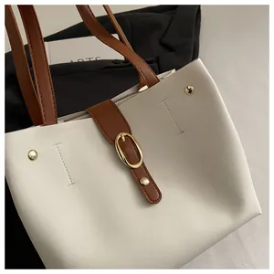 Détail du sac cabas en similicuir crème avec lanières marron et boucle dorée chic