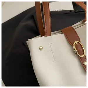 Détail de la boucle dorée et du sac cabas bicolore en cuir synthétique chic