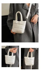 Détails du sac matelassé blanc montrant les poignées épaisses et la bandoulière réglable