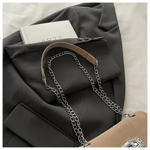 Détail du sac à bandoulière en daim beige avec boucle fer à cheval en strass