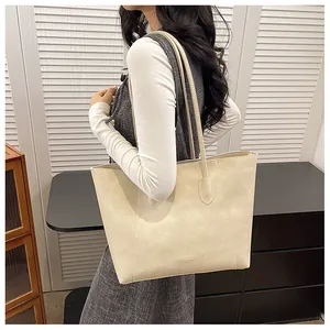 Detail der cremefarbenen Shopper-Tasche mit Vintage-Lederstruktur und Logoprägung