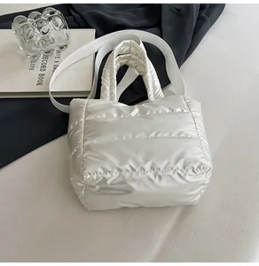 Gros plan sur le sac matelassé blanc perle avec reflet métallisé et large bandoulière