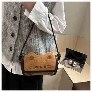 Suede cat-shaped crossbody bag shown on a model in a minimalist lifestyle indoor setting